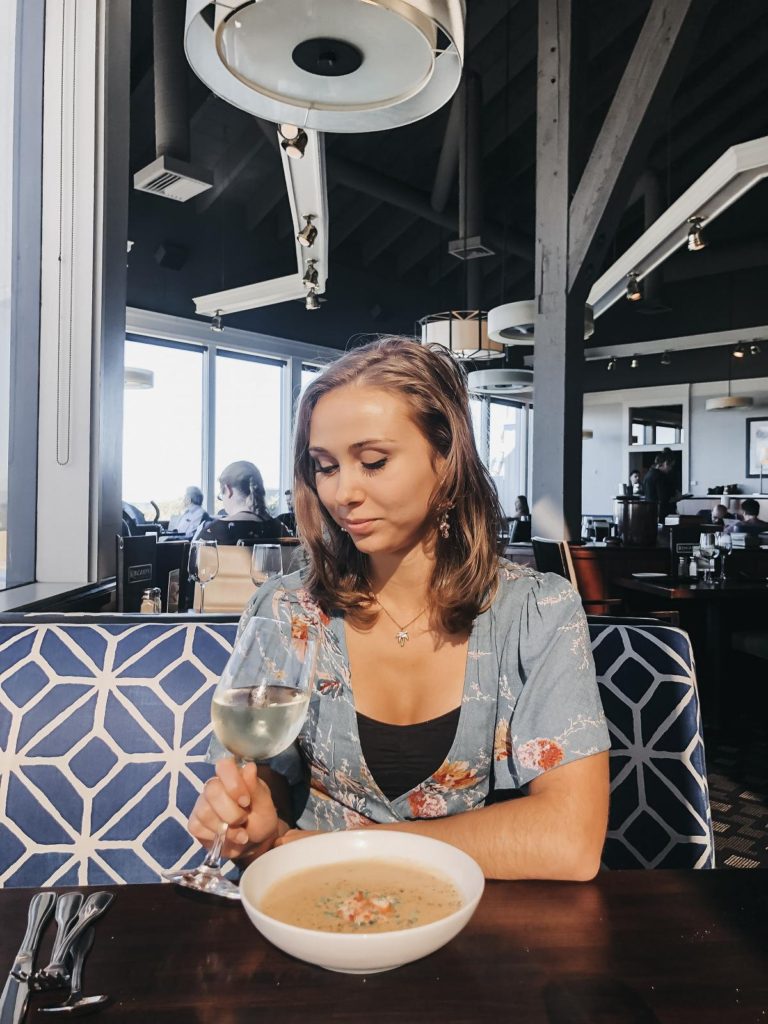 a girl with a glass of wine and bowl of soup at Kincaid's Burlingame