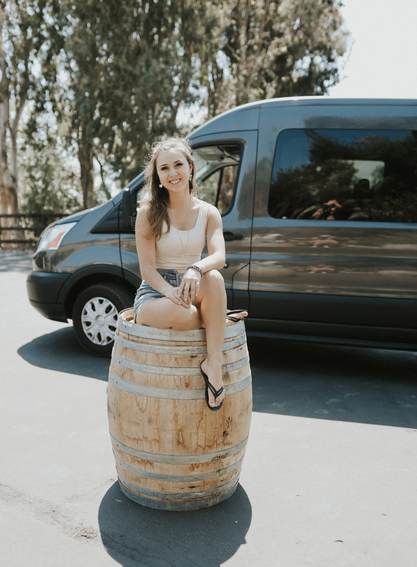 Paige sitting on a barrel while exploring the Santa Barbara wine trail