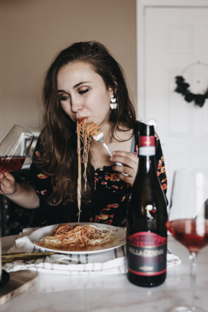 Paige eating pasta paired with wine