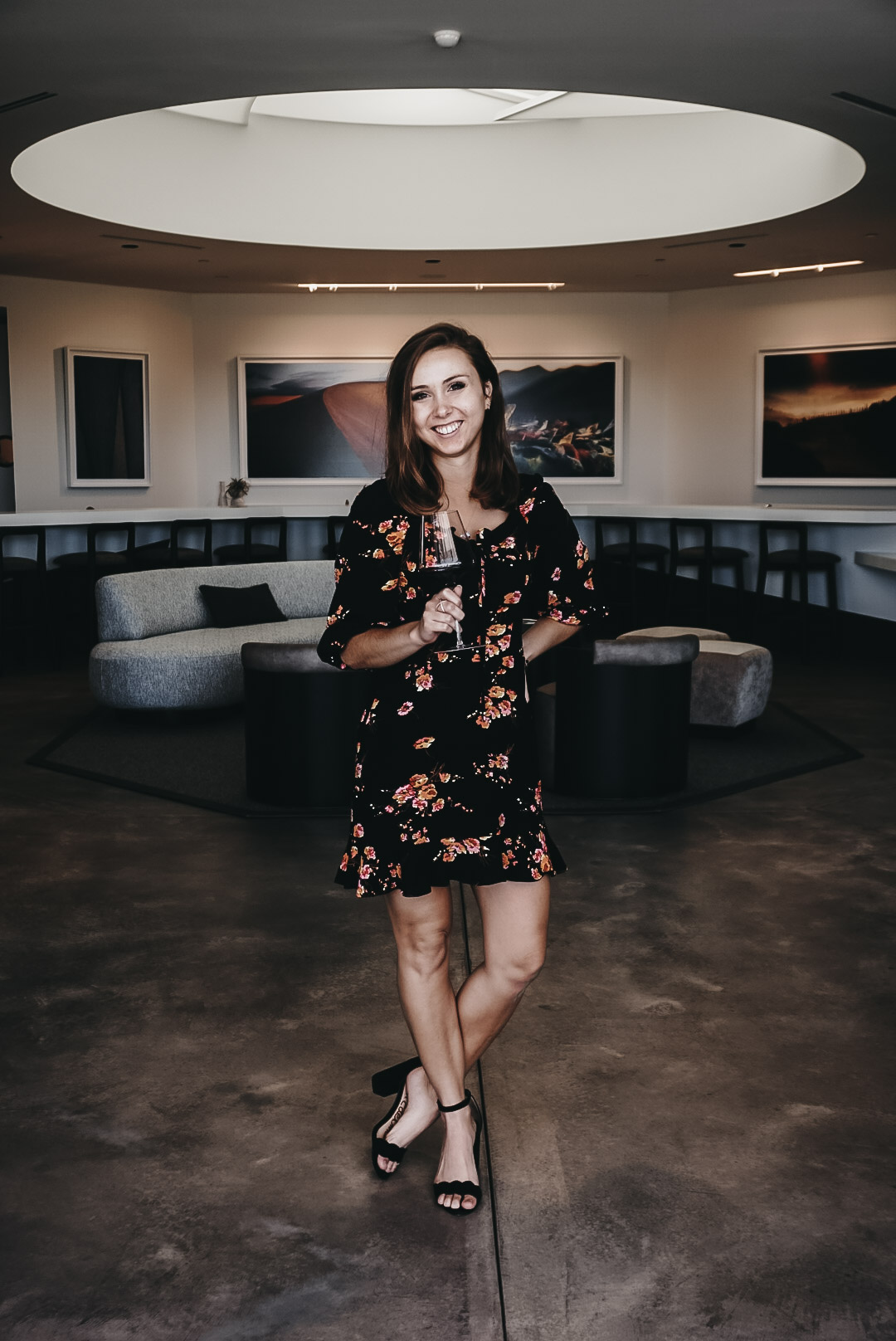 A girl posing in front of the artwork at Aperture Cellars