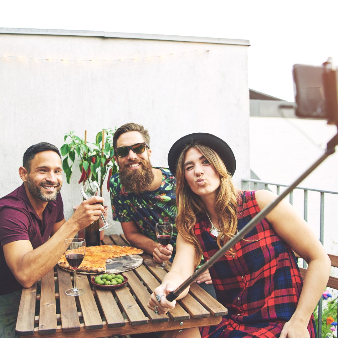 3 friends taking a picture of their wine to post on the Vinofy app