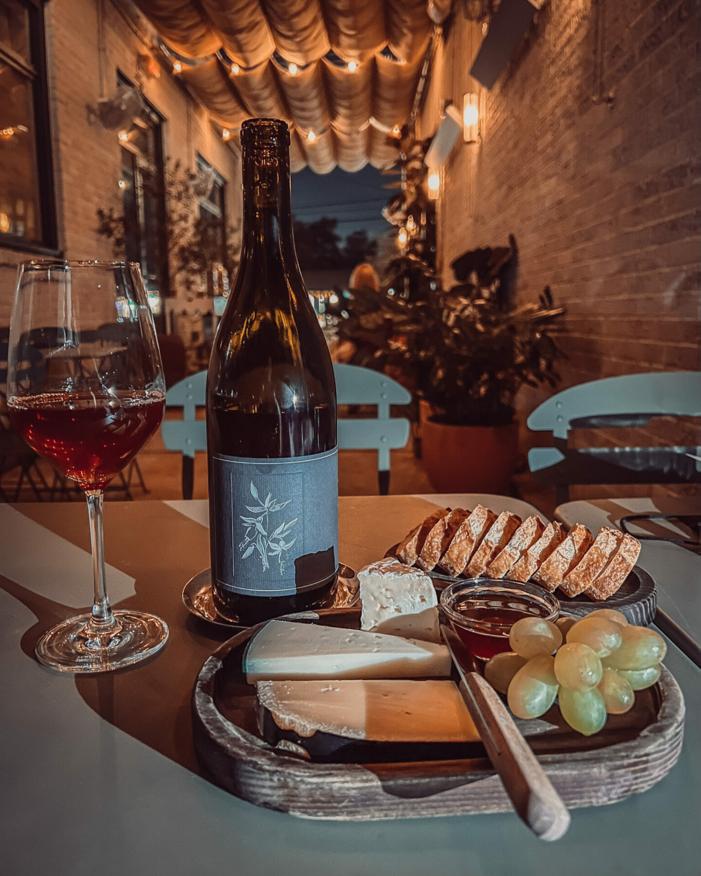 a cheese platter and bottle of wine from Montrose Cheese & Wine, on a list of Houston wine bars
