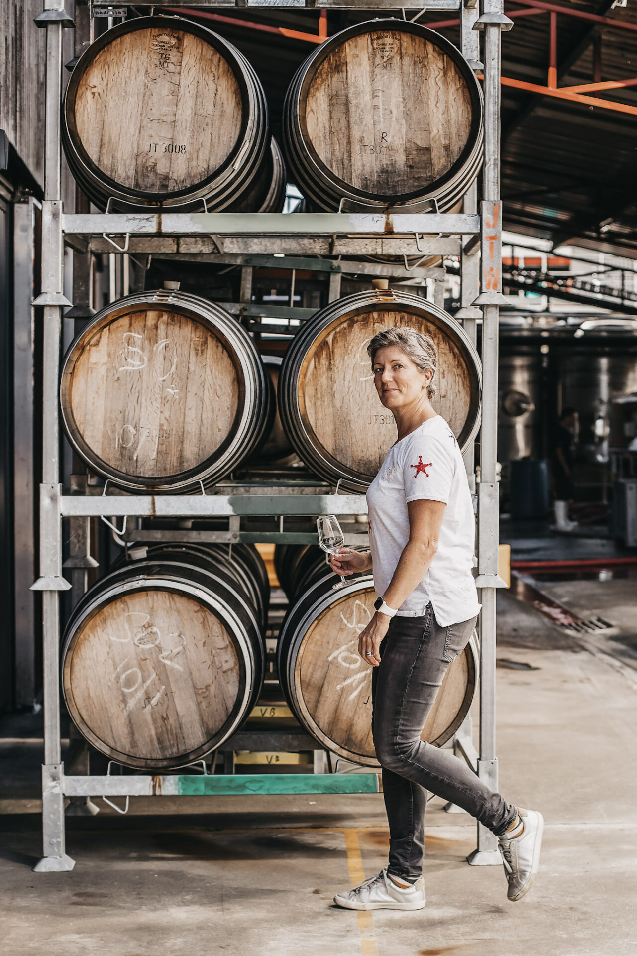 Jules Taylor in front of wine barrels