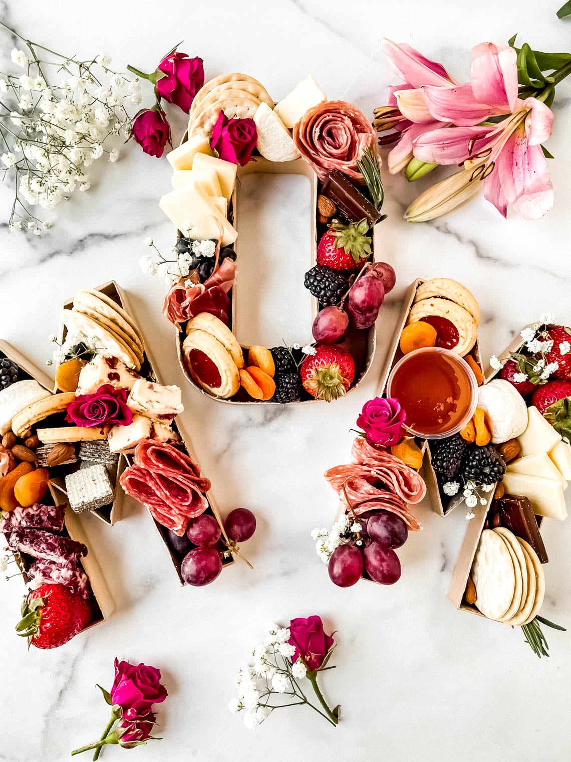 A Mother's Day Charcuterie board that spells out the word "Mom"