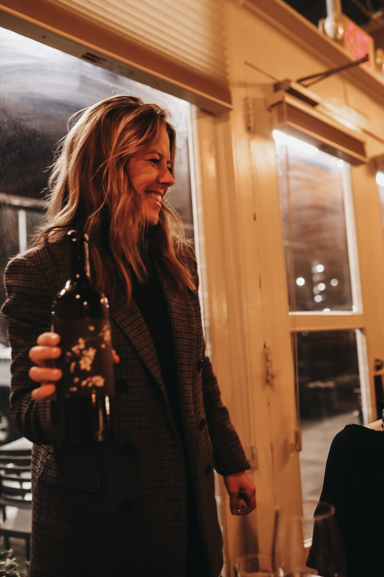 Ashley Trout holding a bottle of Brook & Bull wine