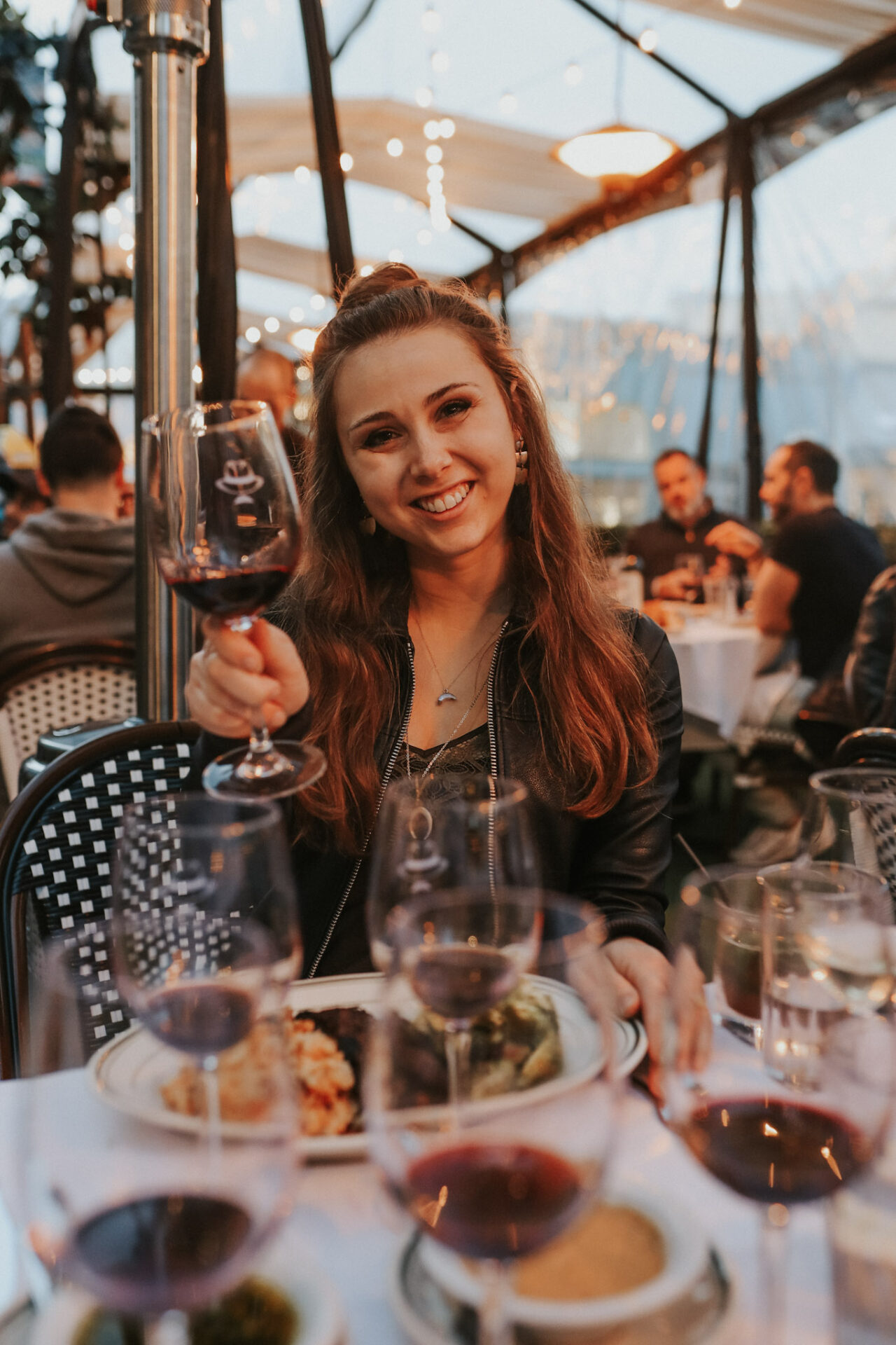 Paige eating on the patio at Izzy's Steakhouse with red wine in hand