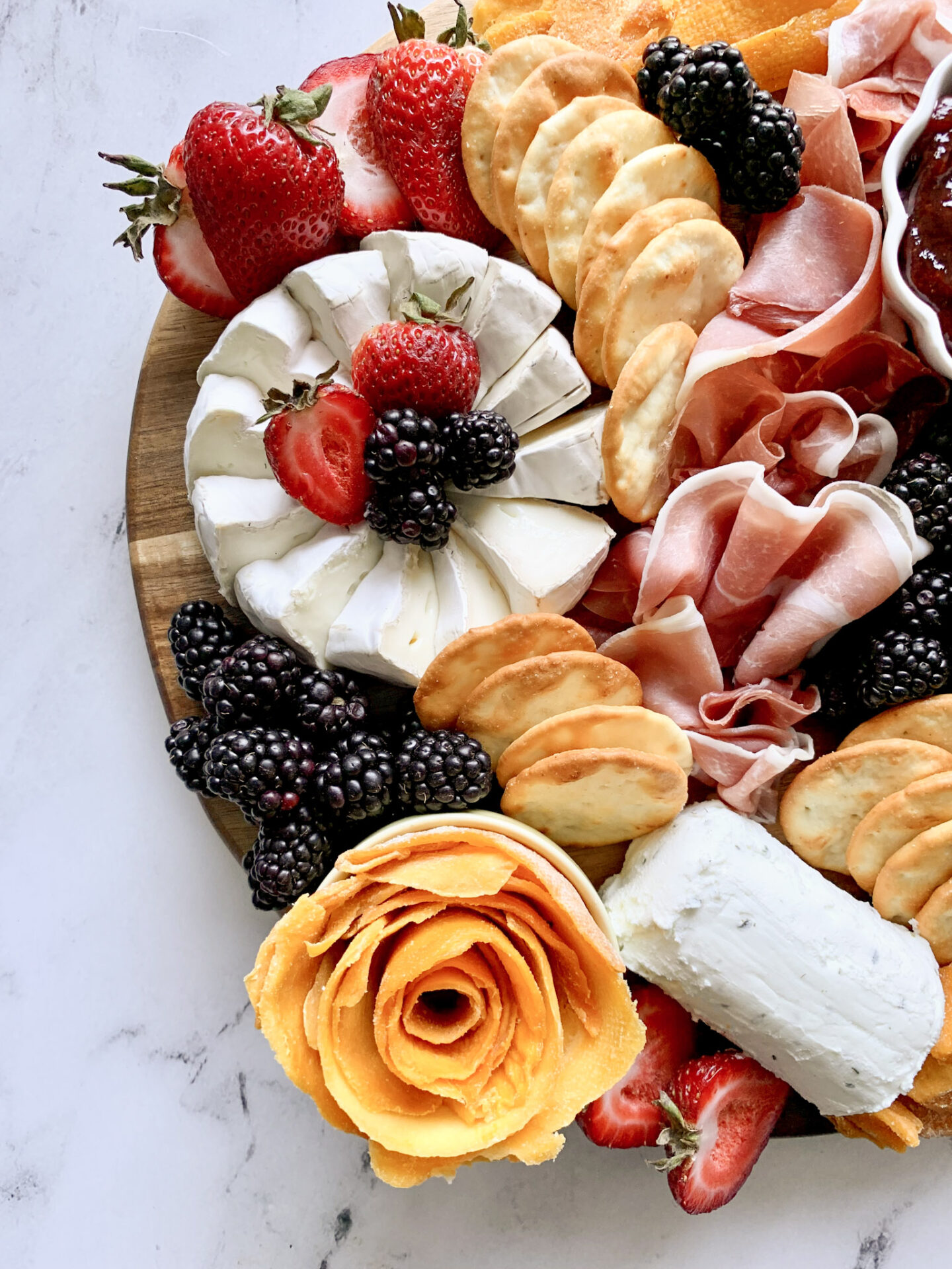 Closeup of Aldi Charcuterie Board with brie strawberries mango rose goat cheese