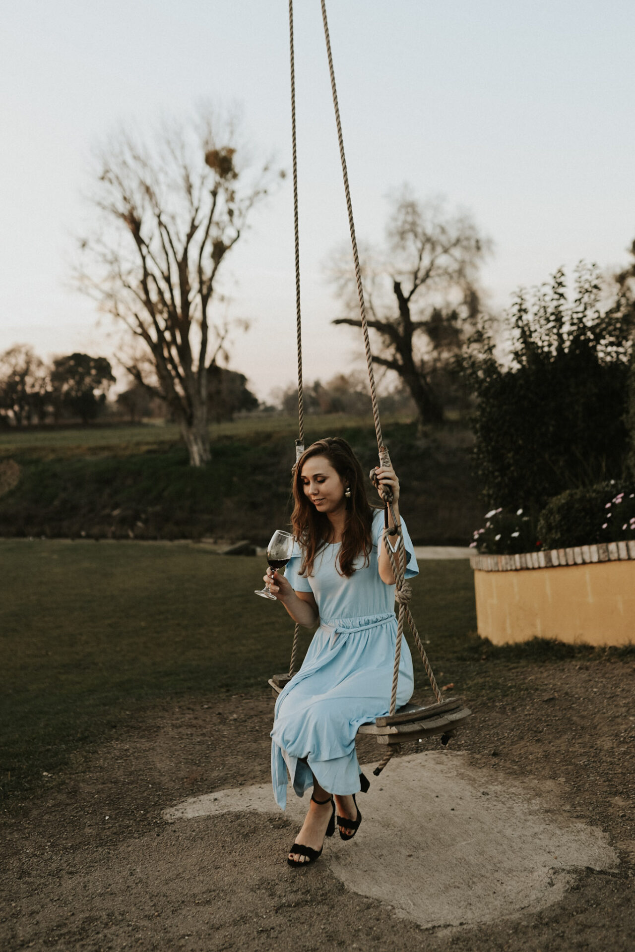 girl on a swing at a winery, practicing wine tasting etiquette