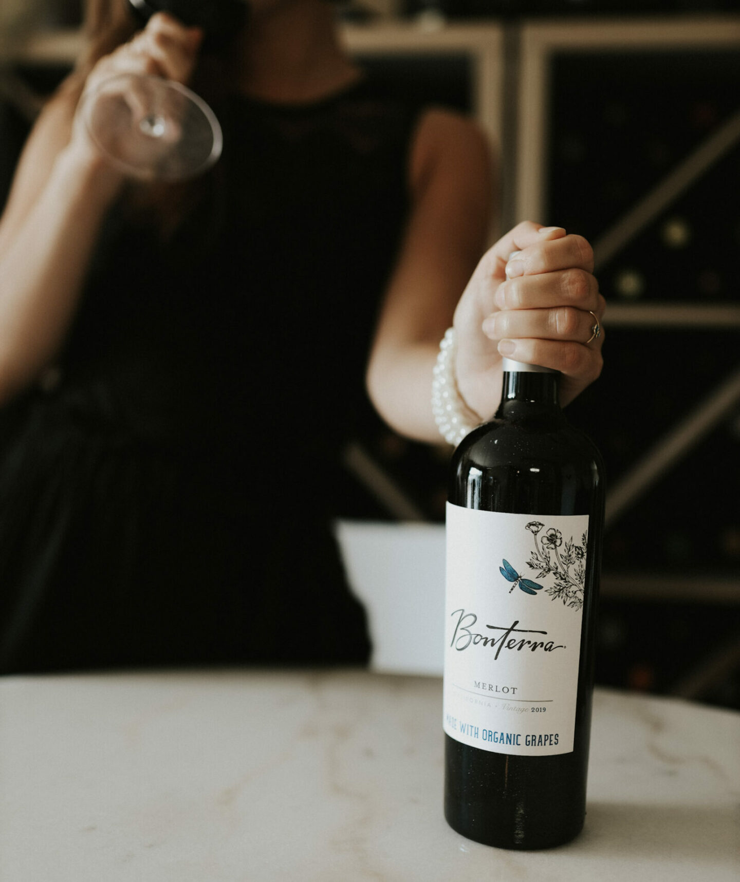 A hand holds a bottle of Bonterra Merlot - one of the best Merlot wines
