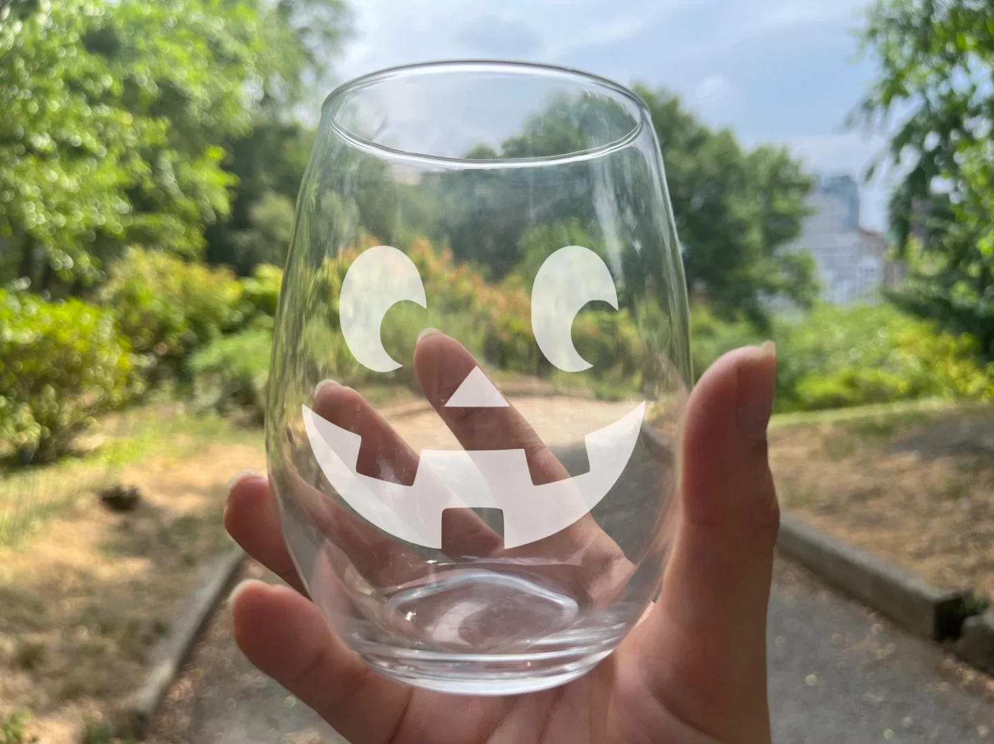 Etched Jack-o-Lantern Stemless Halloween Wine Glass held by a hand