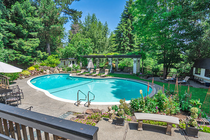 Empty pool surrounded by outdoor lounge furniture