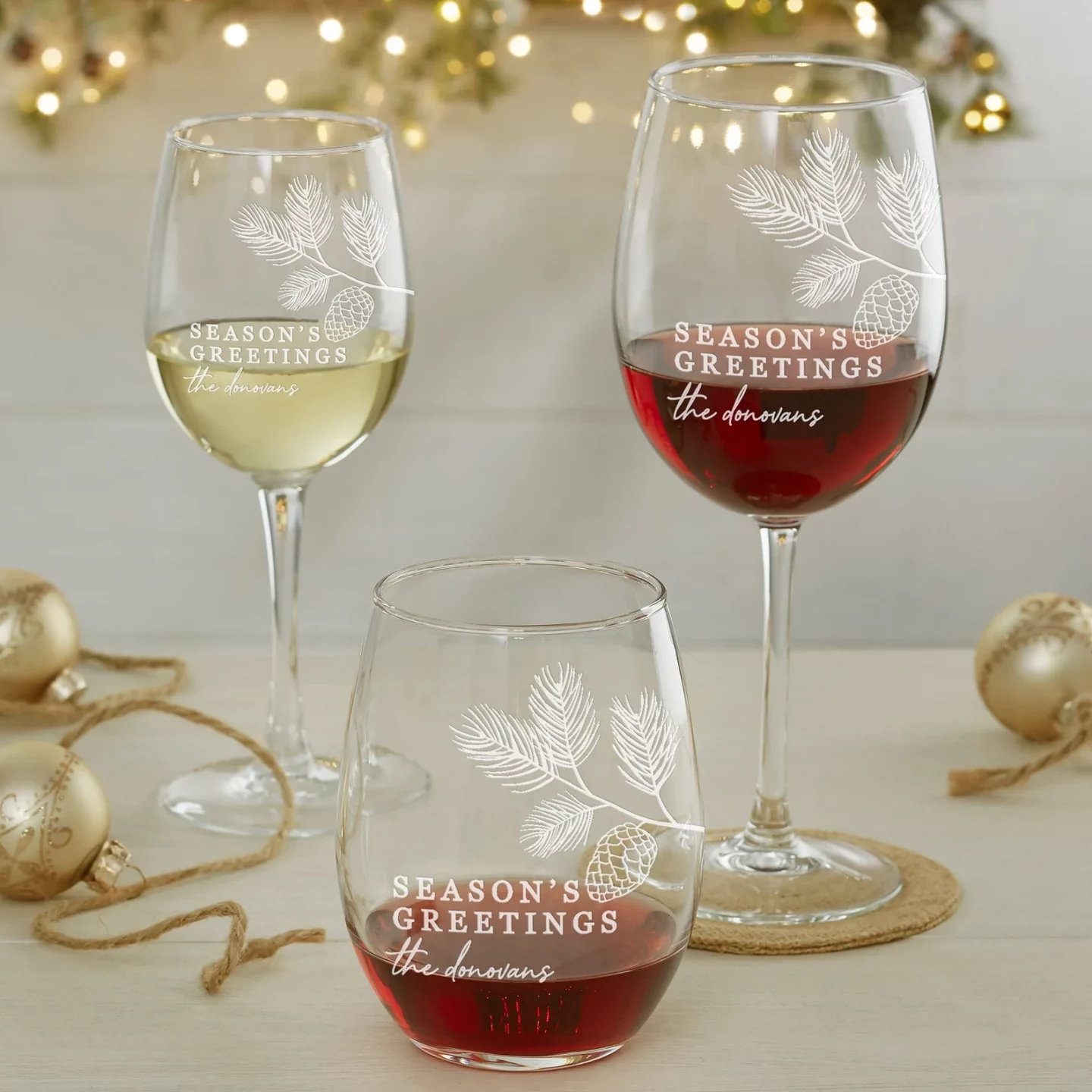 Two Stemmed Wine glasses and a Stemless Wine Glass pictured in front of holiday decor