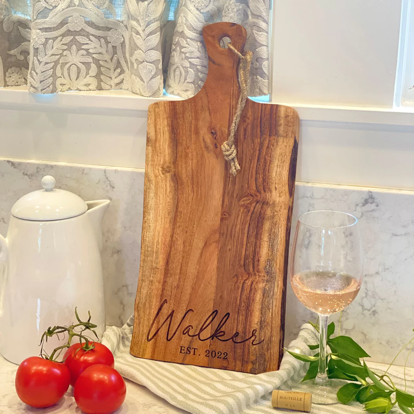 Personalized, live edge charcuterie board set next to a glass of wine