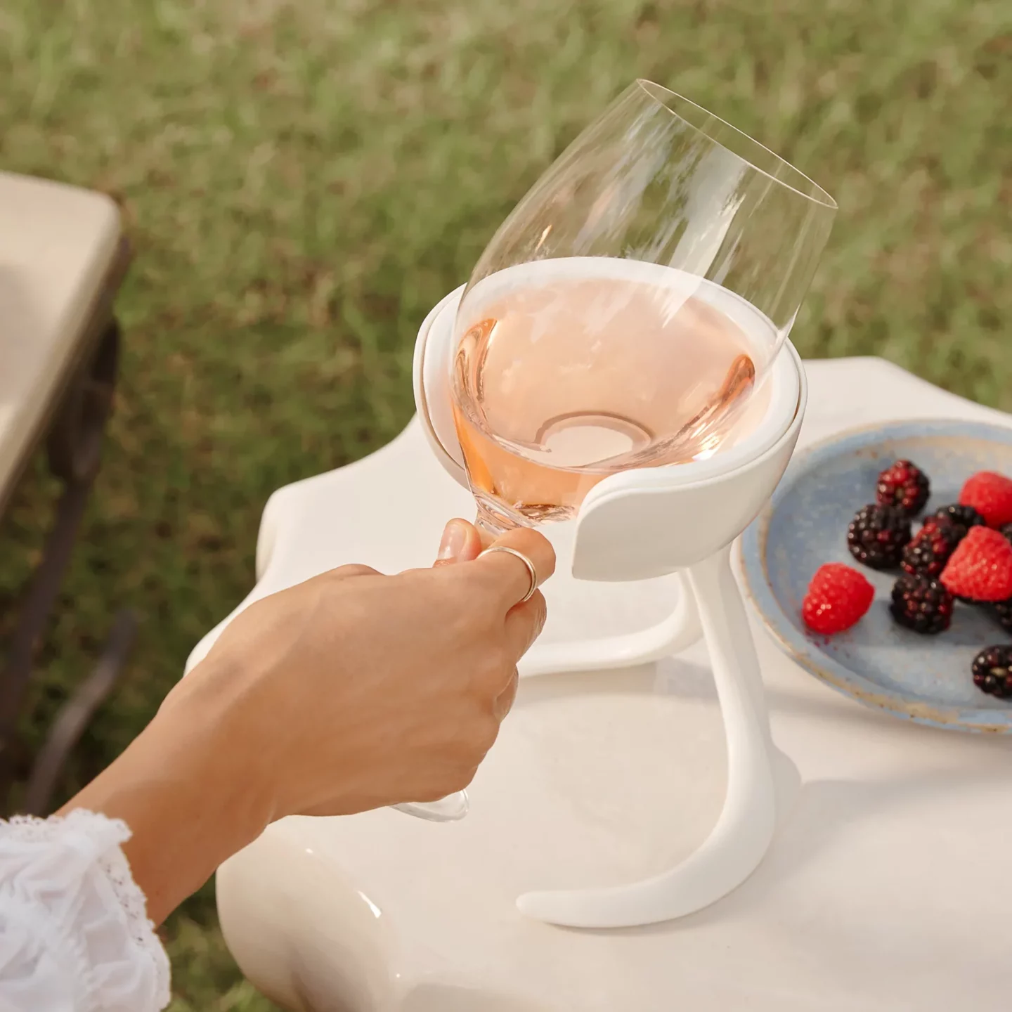 Hand holding a stemmed wine glass in a wine chiller