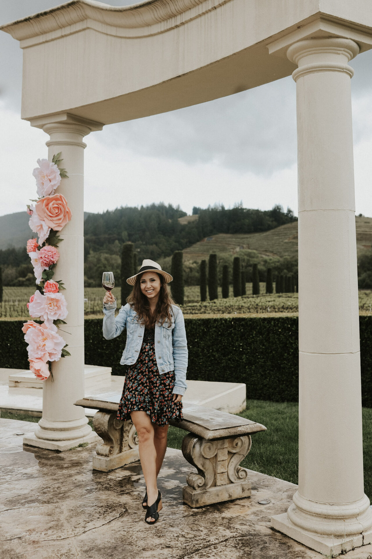 Paige at Ferrari Carano Winery in Dry Creek Valley with a beautiful white arch and vineyards in the background