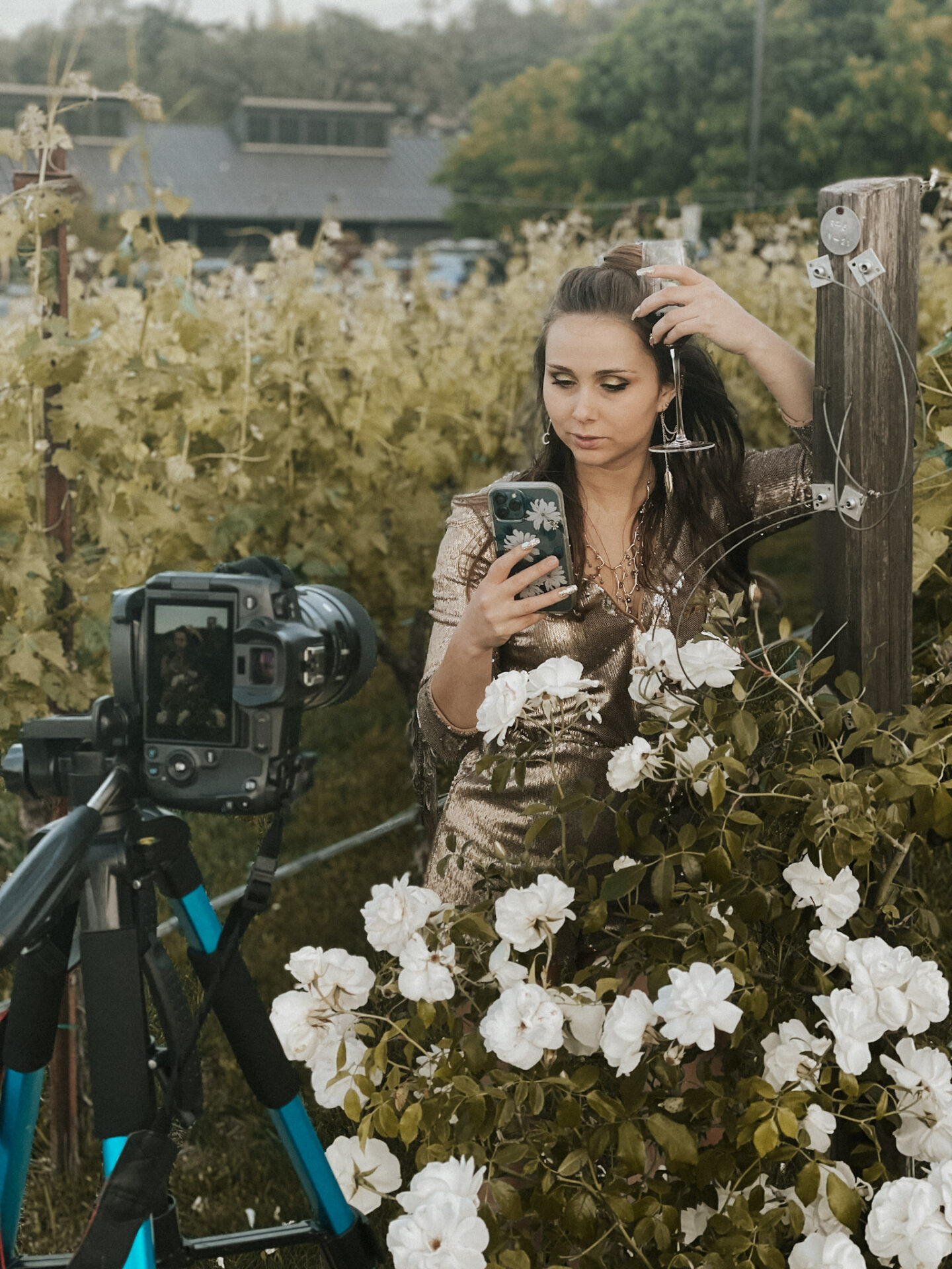 Paige taking a photo of herself in a vineyard with a camera and tripod