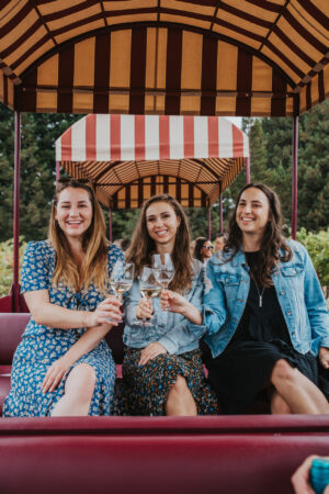 Paige and friends drink wine on a trolley