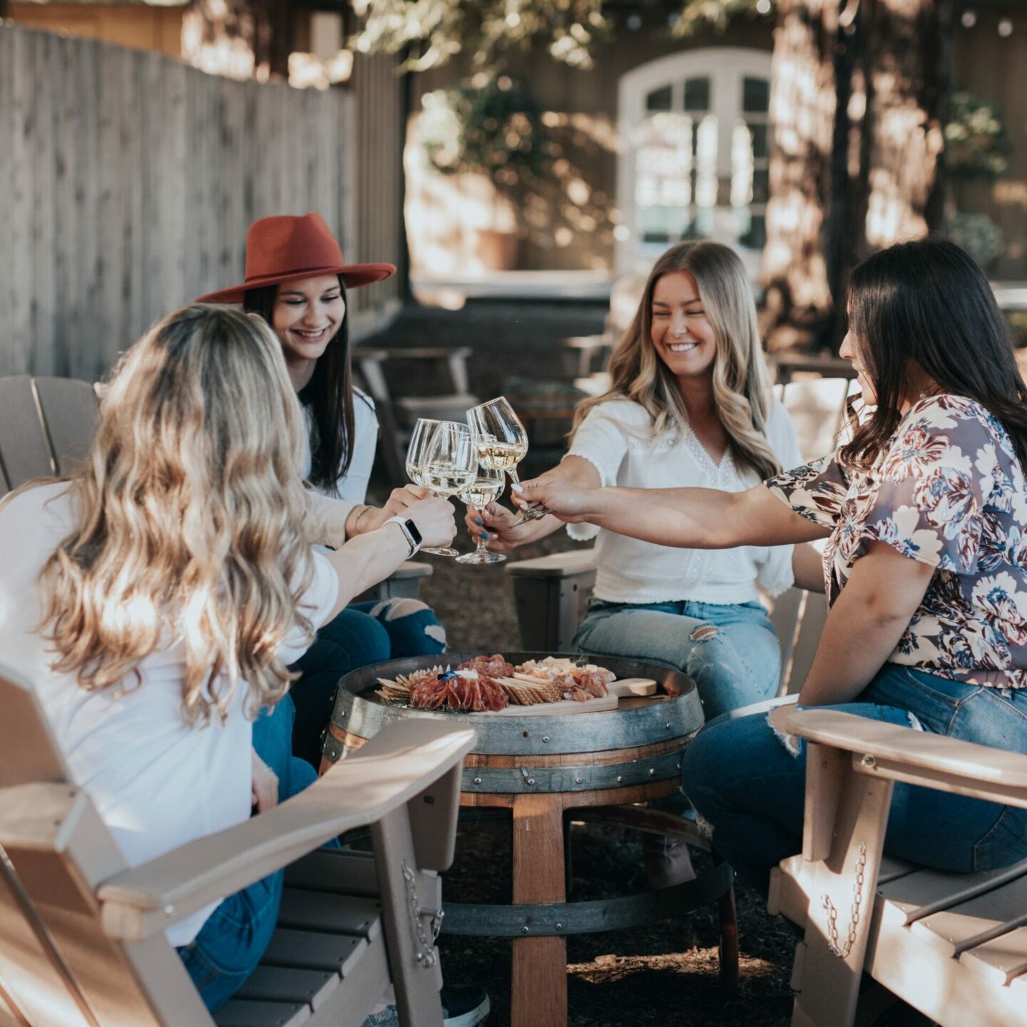 Women sitting around an outdoor table to enjoy a glass of wine