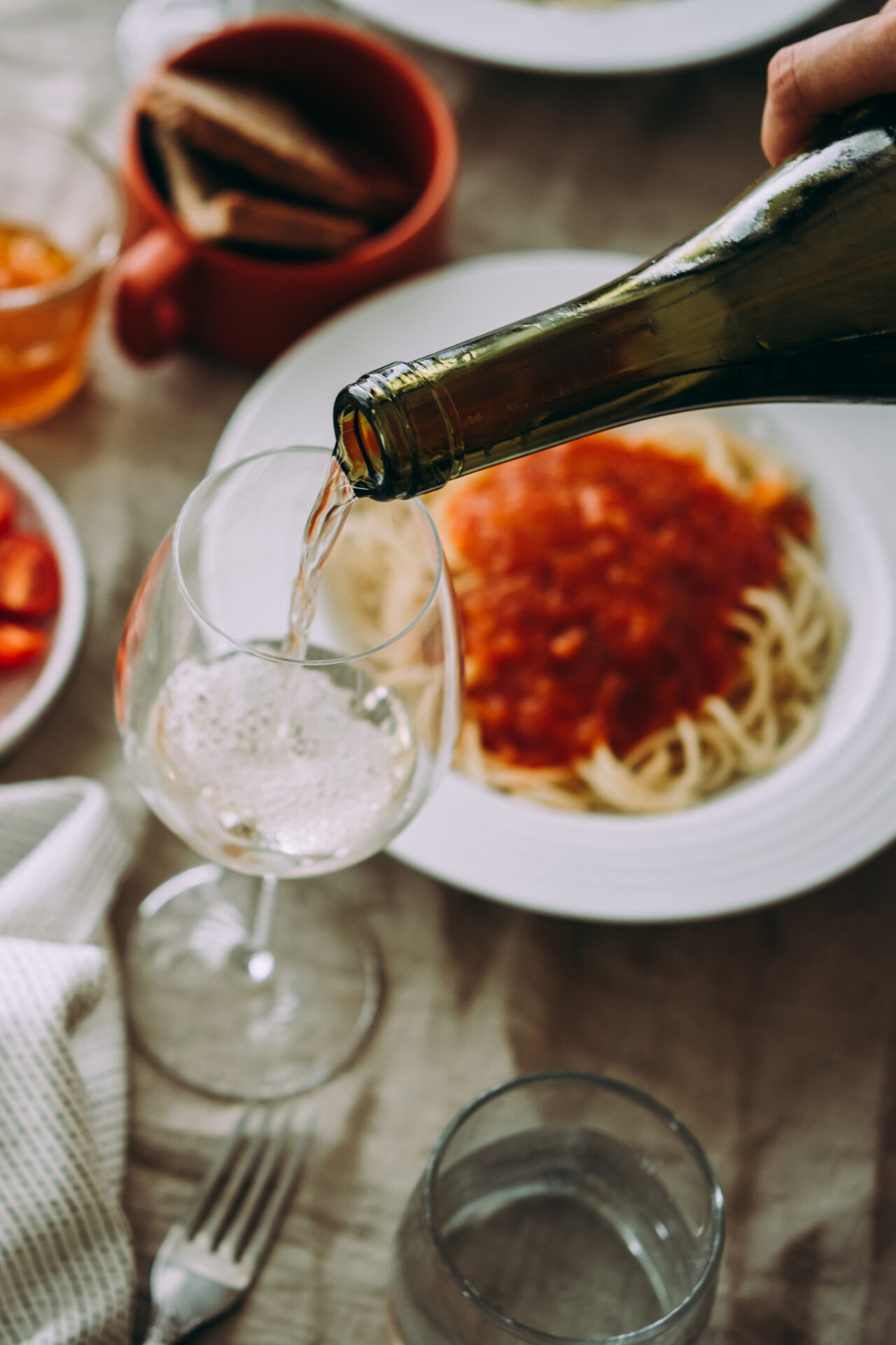 Garganega (Soave) Wine being poured into a wine glass with pasta