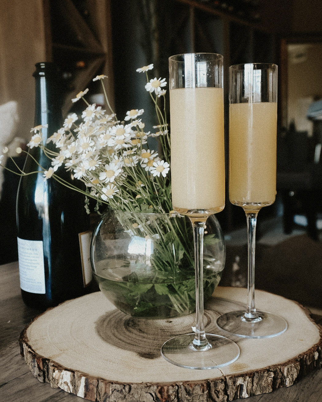 The Best Prosecco for Mimosas - two champagne flutes with flowers behind