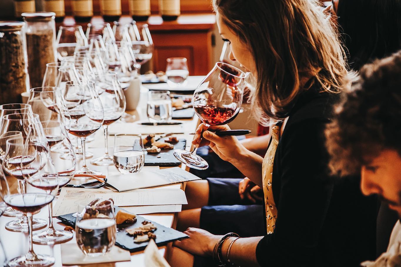 Paige sniffing a red wine at a sit-down tasting