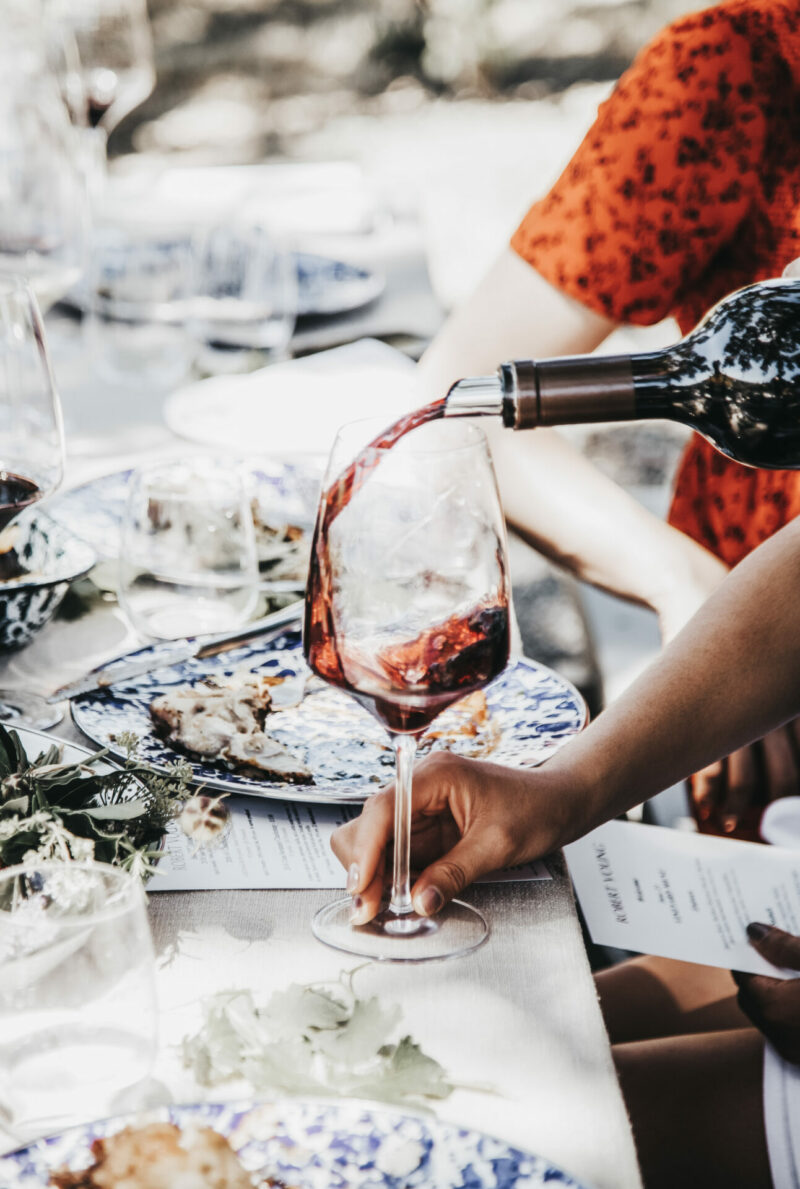 Glass of red wine being poured at a sit down tastings