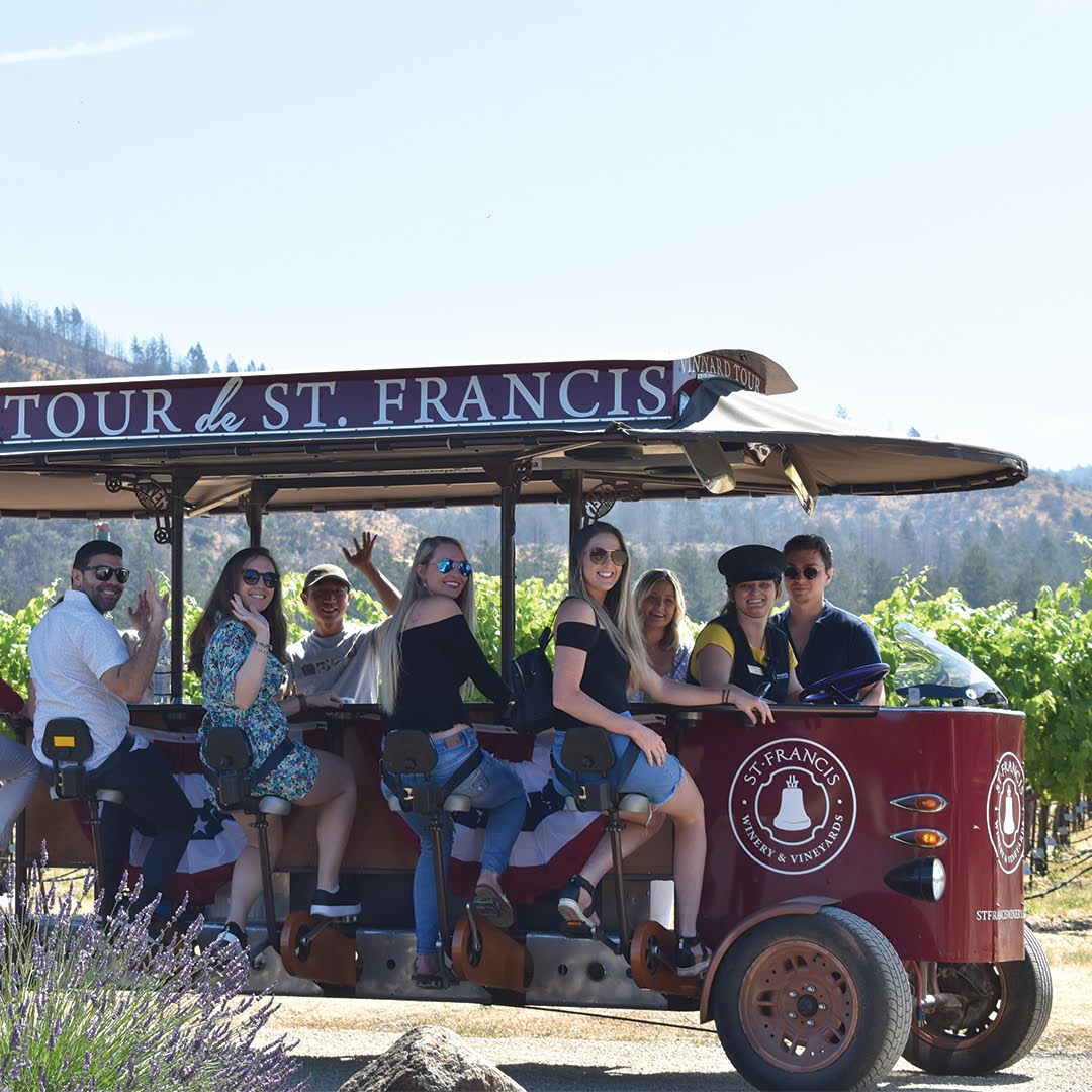 A group of people seated on a pedal trolley at St. Francis Vineyard & Winery in Kenwood, CA