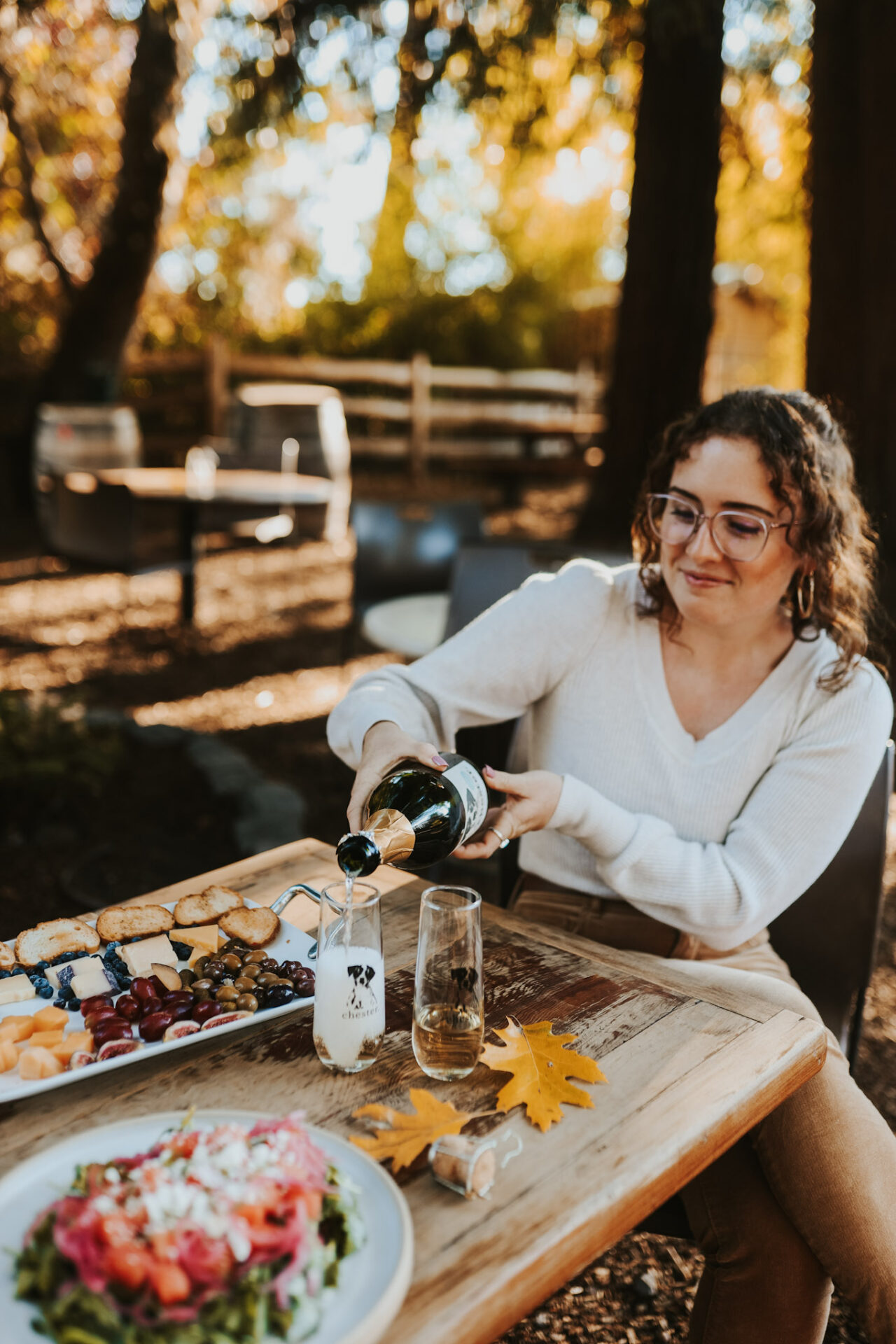 Woman pouring sparkling wine into a glass paired with food