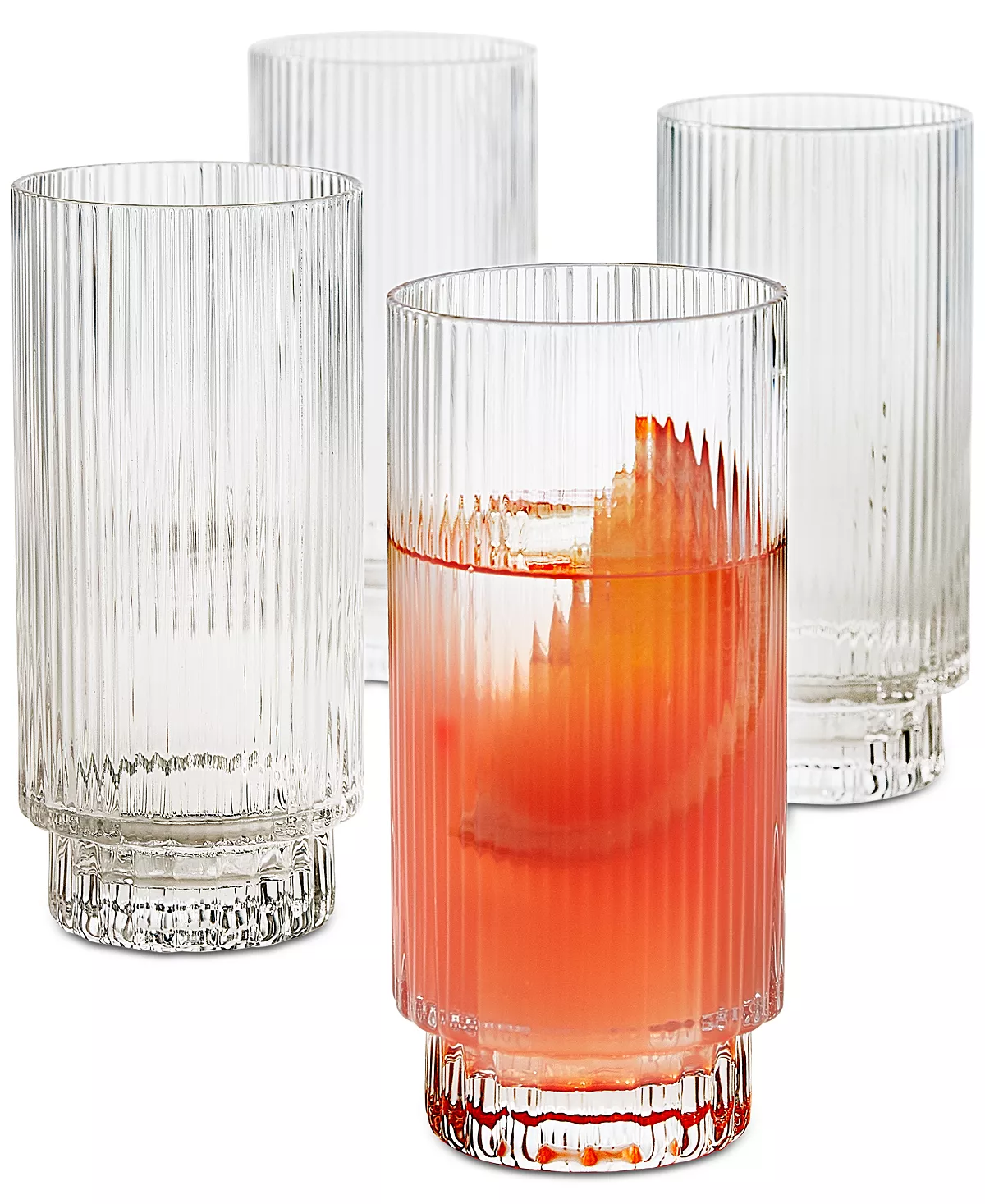 Four highball glasses, one of which is holding a grapefruit cocktail