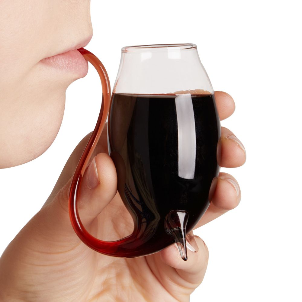 A person sipping port wine out of a small glass with a straw