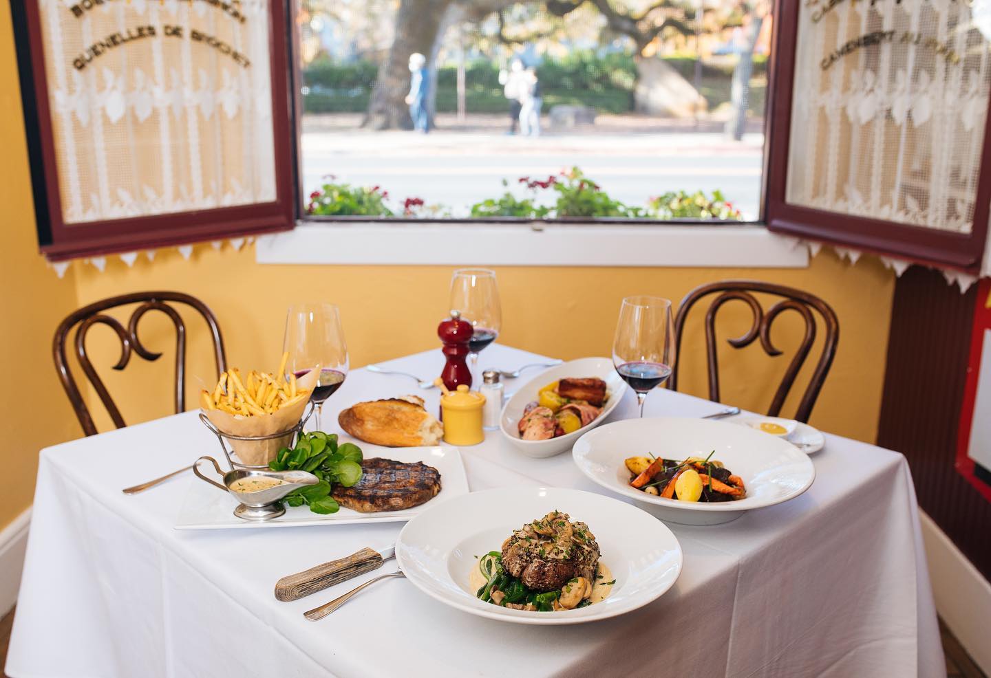 A set table in front of a picturesque window at Bistro Jeanty in Yountville, CA