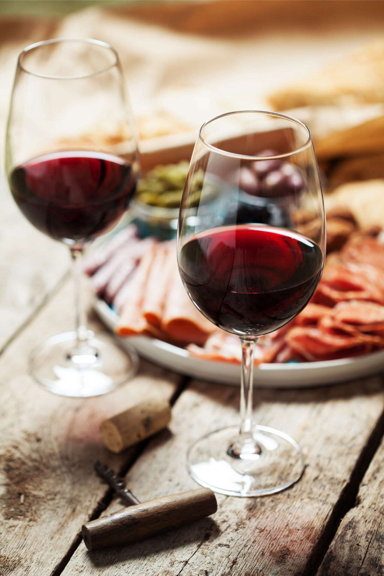 Two glasses of Nerello Mascalese wine in front of a charcuterie plate