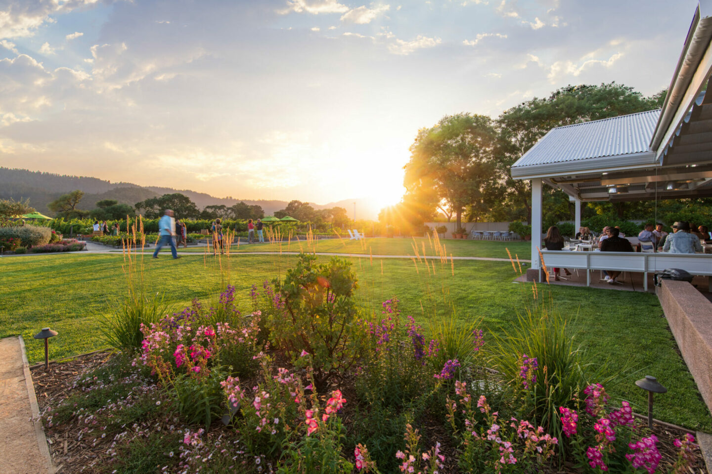 Exterior shot of Brix Restaurant and Gardens at sunset, while people enjoy al fresco dining