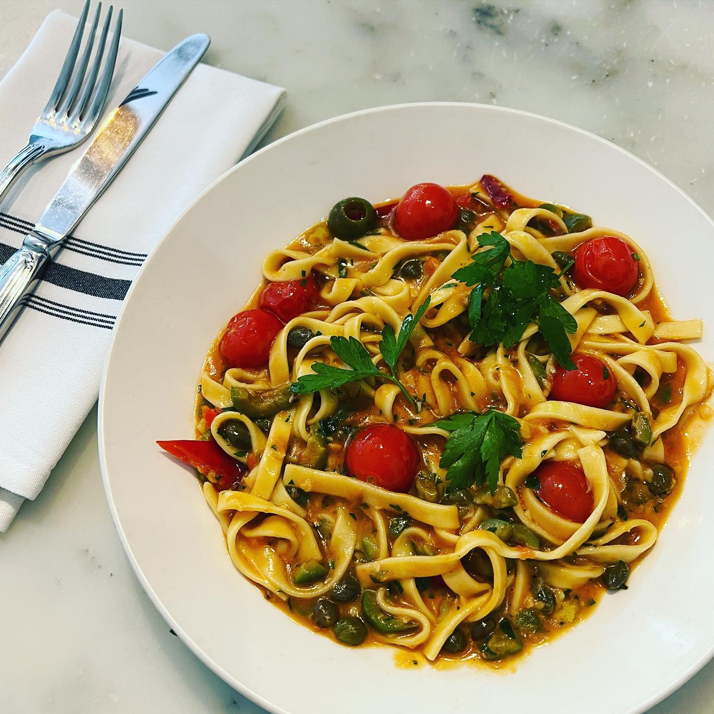 Plate of pasta with tomatoes and herbs