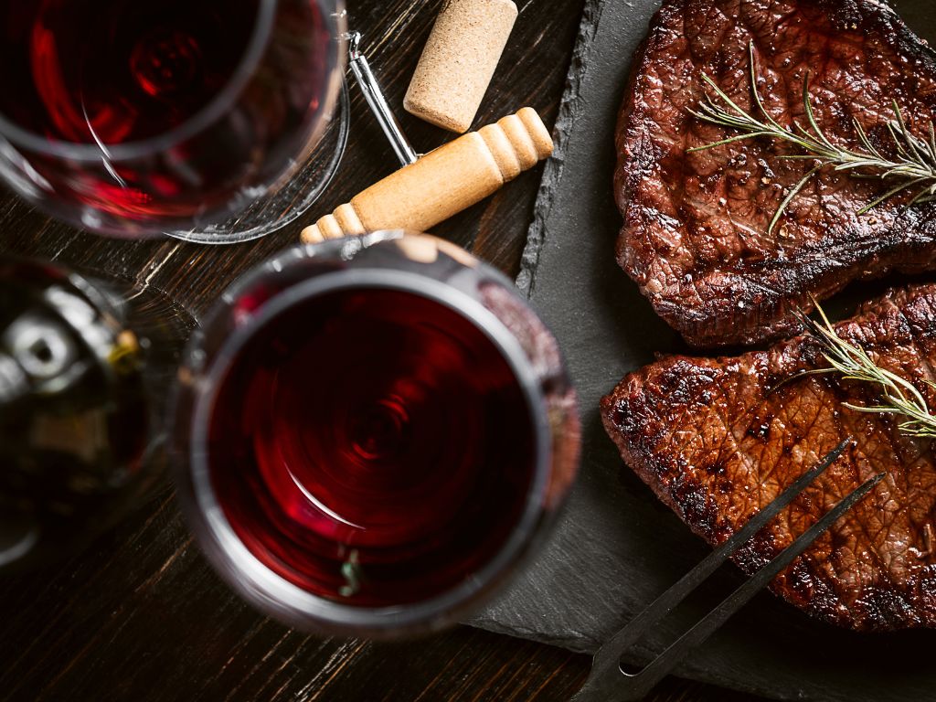 Red wine paired with steak on a plate