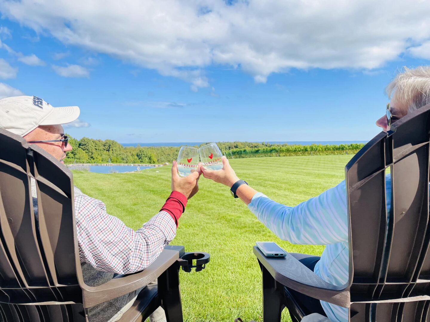 Two people clink glasses at Verterra Winery in Leelanau Peninsula, MI