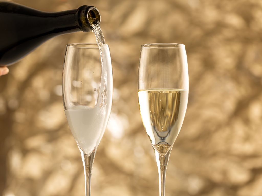 Asti Spumante champagne flutes with bottle pouring into glasses