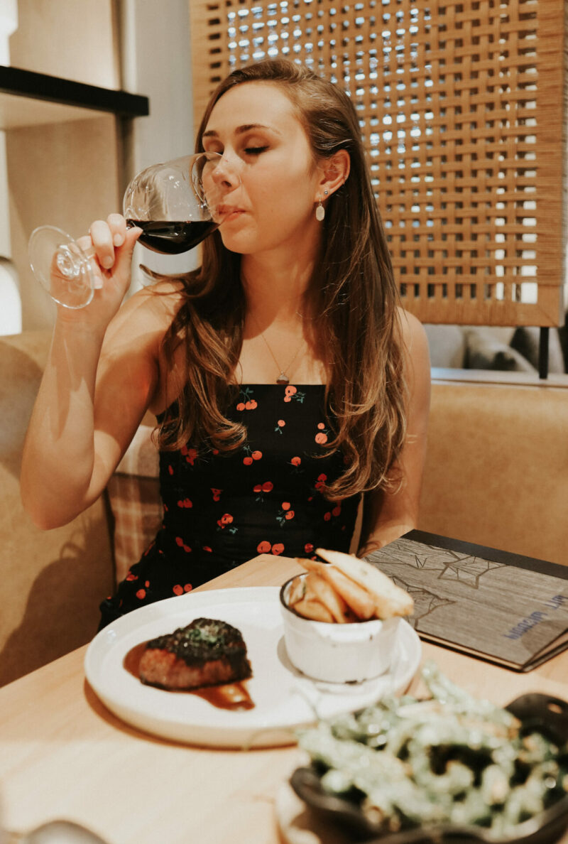 Paige drinking a glass of wine at dinner at Wit & Wisdom in downtown Sonoma