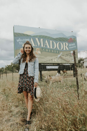 Paige in front of a sign for Amador wineries