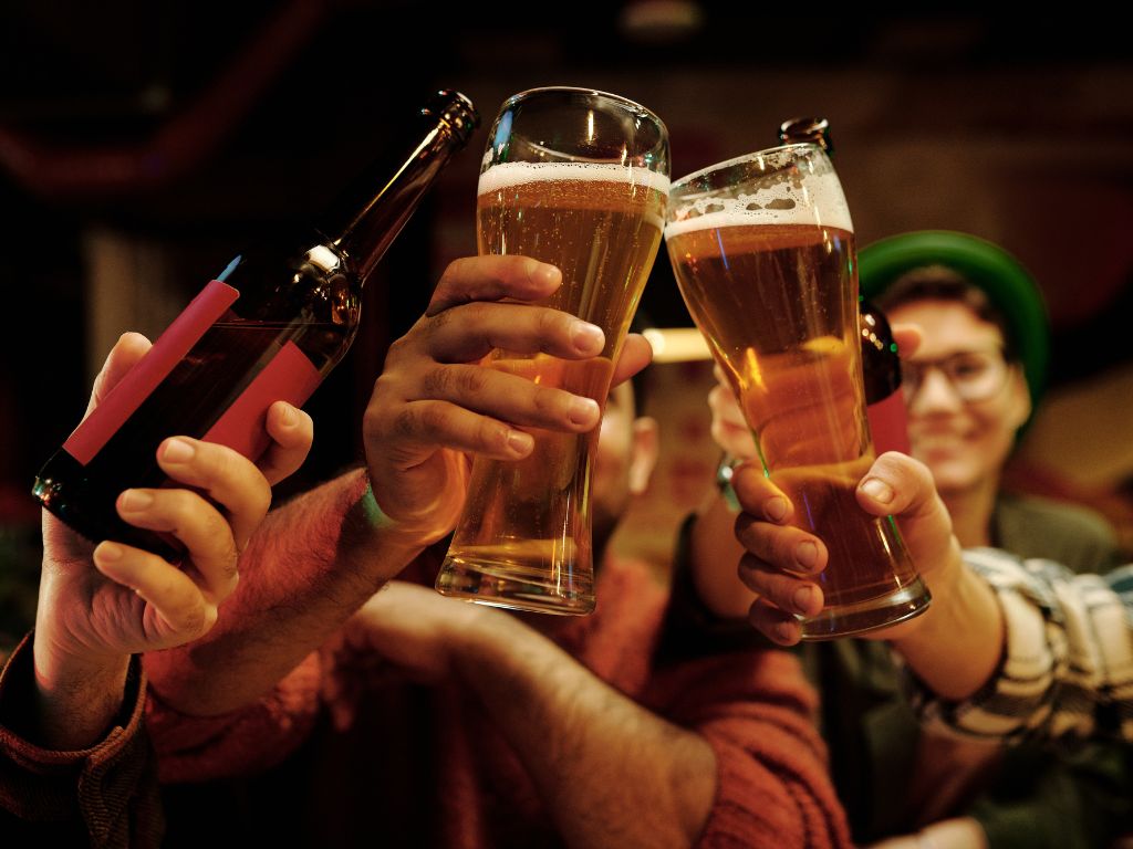 Three friends cheersing beers for beer puns