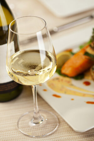 Is Pinot Grigio Sweet? Dry Pinot Grigio white wine in a glass next to food