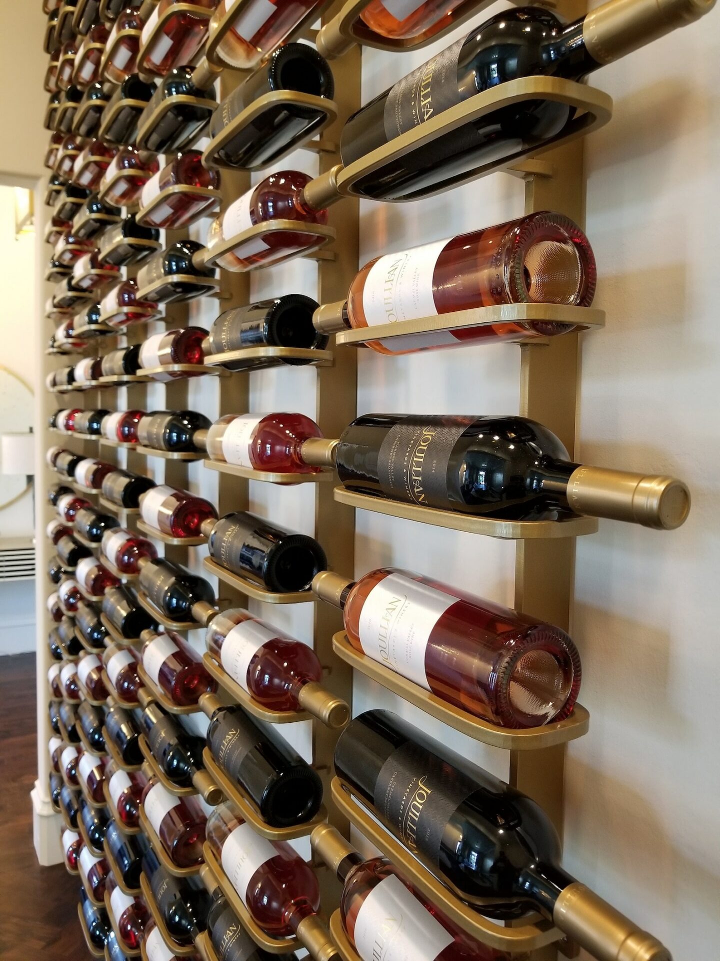 Gold brushed blade wine racks mounted along a wall