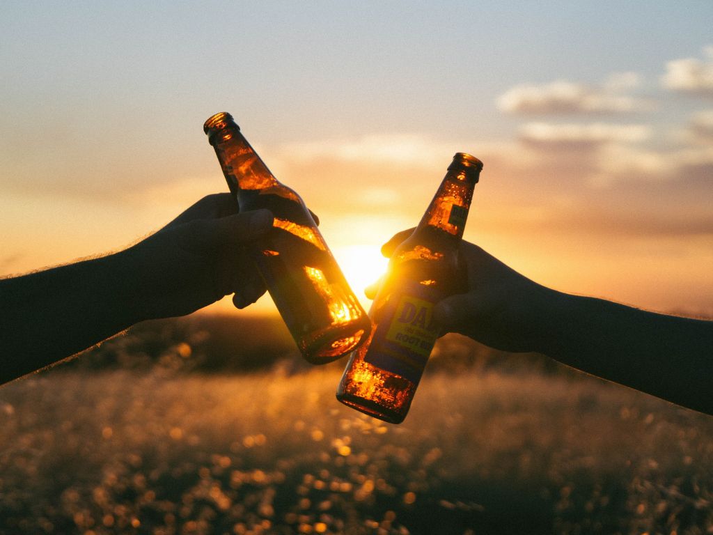 Two friends cheersing while telling funny beer quotes