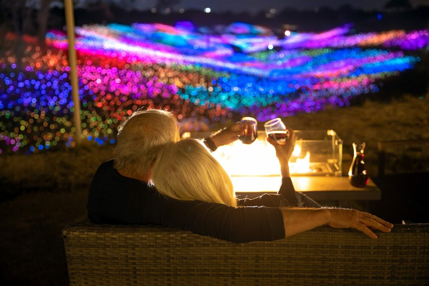 Two people enjoying a light instillation display and wine in Paso Robles, CA