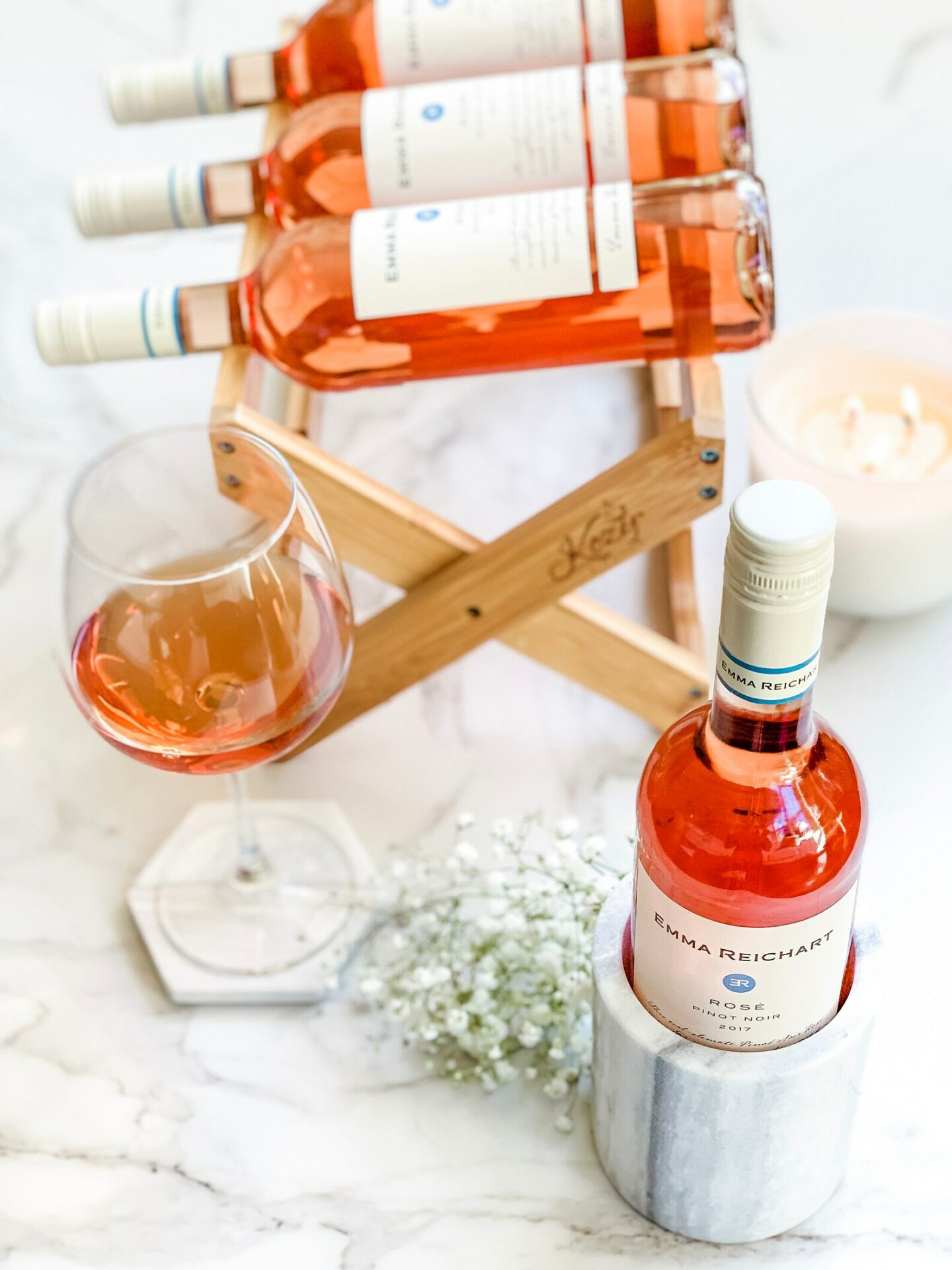 Wooden wine rack set on the counter top with rose and a wine chiller