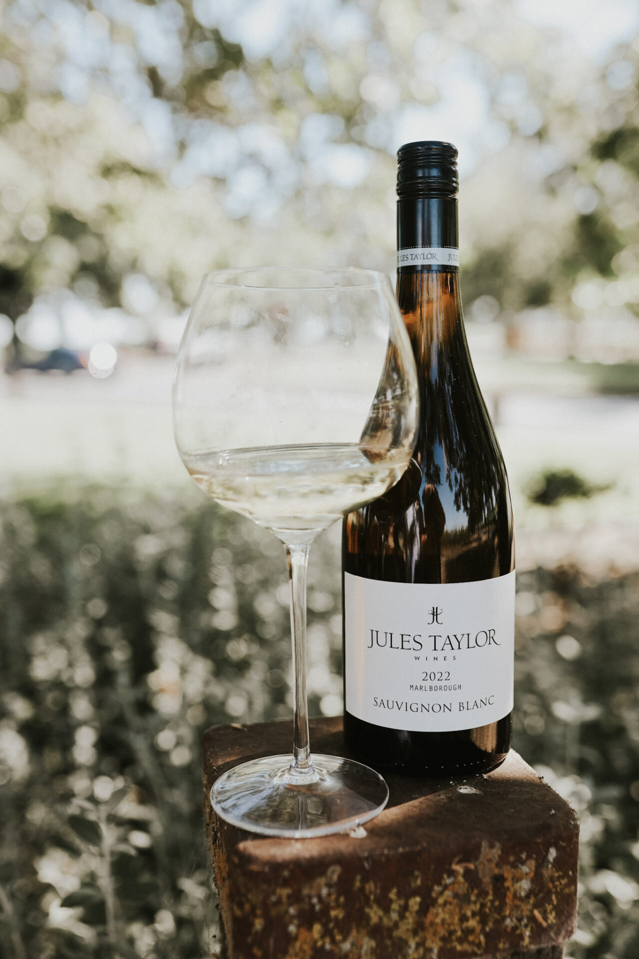 Jules Taylor Sauvignon Blanc with a white wine glass sitting on a fence post
