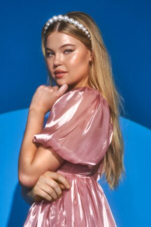 Girl wearing pearl headband and shiny pink dress