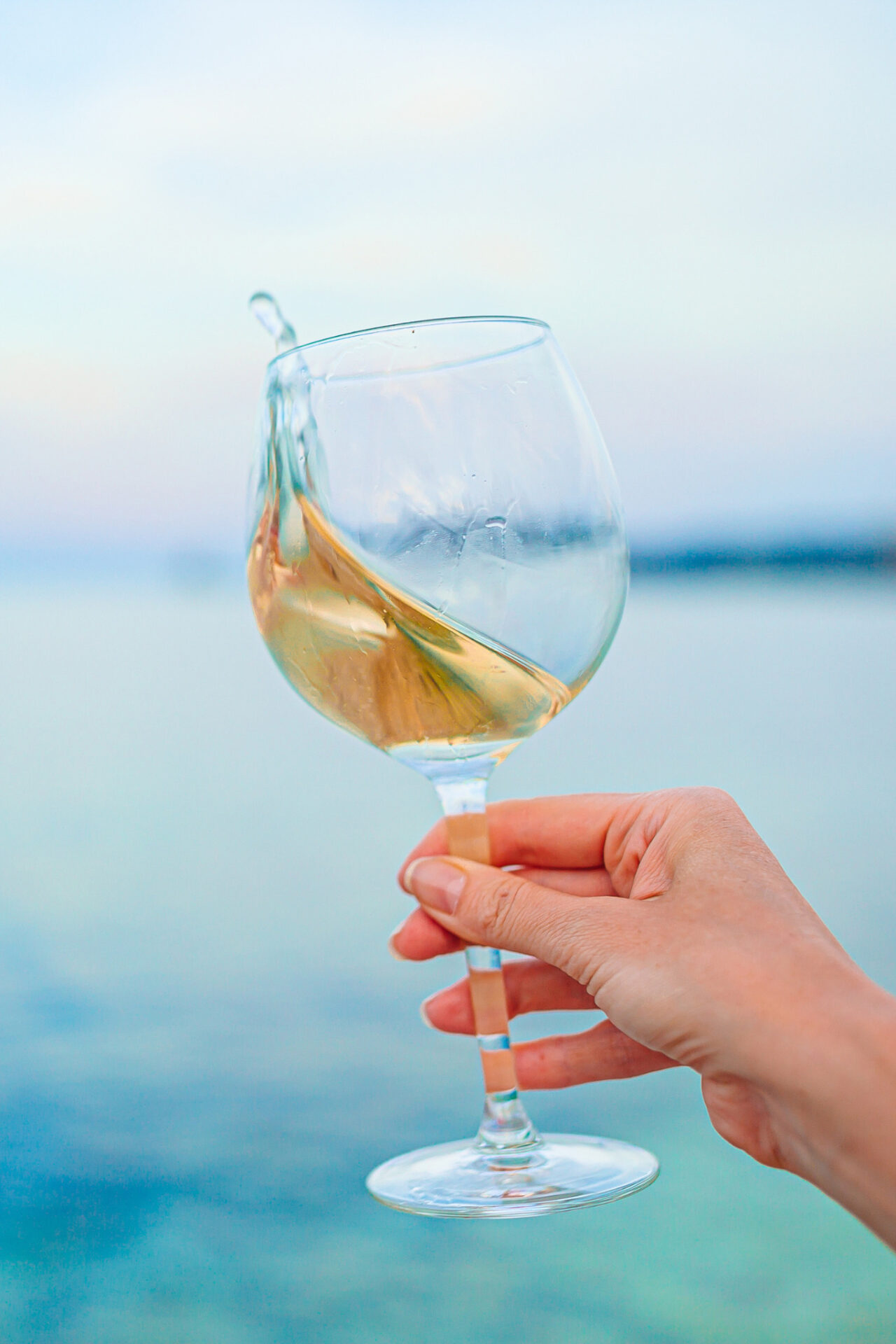Sauvignon Blanc splashing out of a white wine glass with water in the background - Calories in Sauvignon Blanc