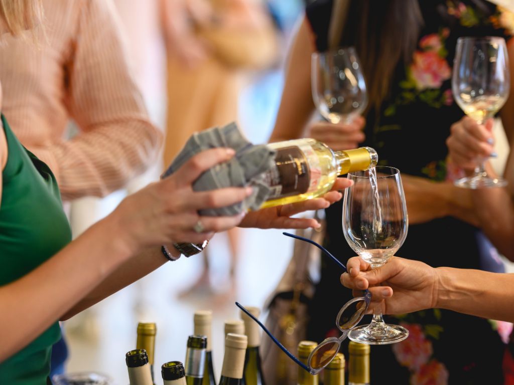 Sauvignon Blanc being poured at a party with multiple glasses