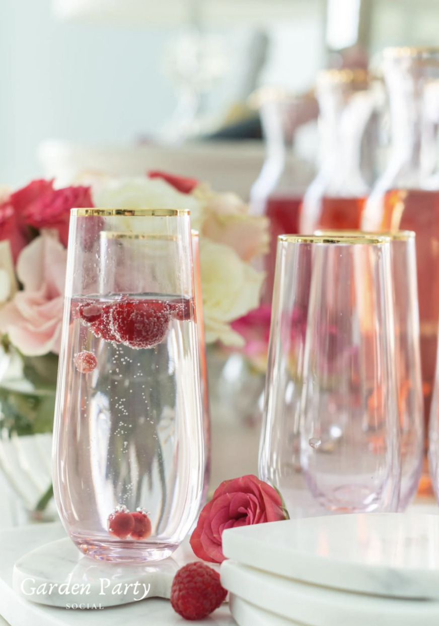 Stemless champagne flues with gold rims and raspberries